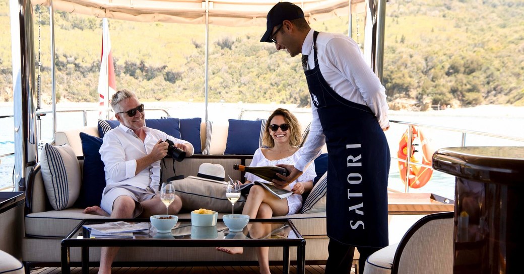 charterers being poured champagne on a yacht