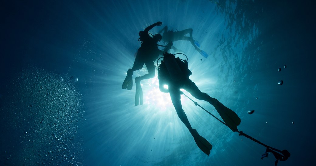 Scuba divers holding on to the rope underwater
