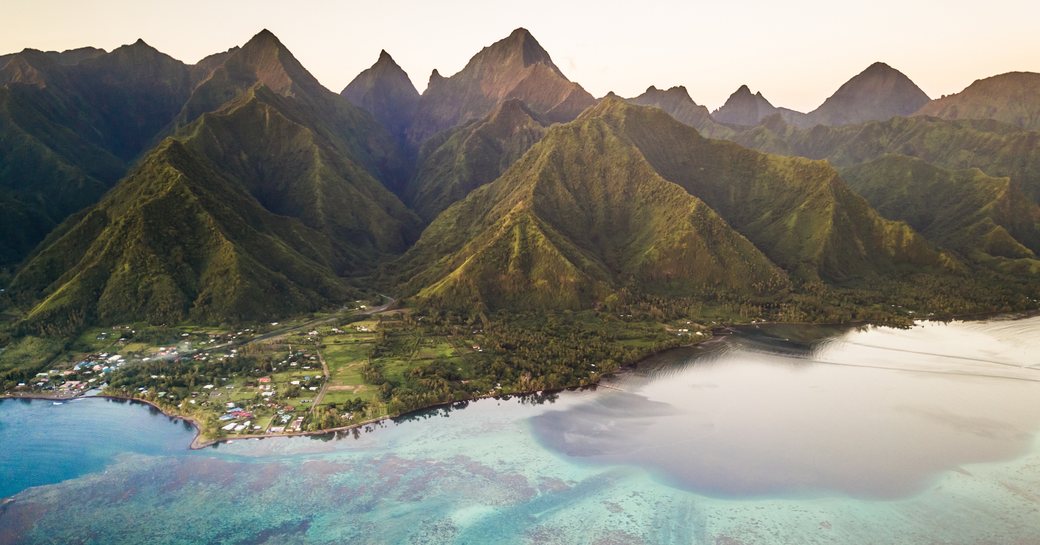 Aerial view of coral reef with The Mighty Mount Aorai in the back ground in Tahiti, French Polynesia