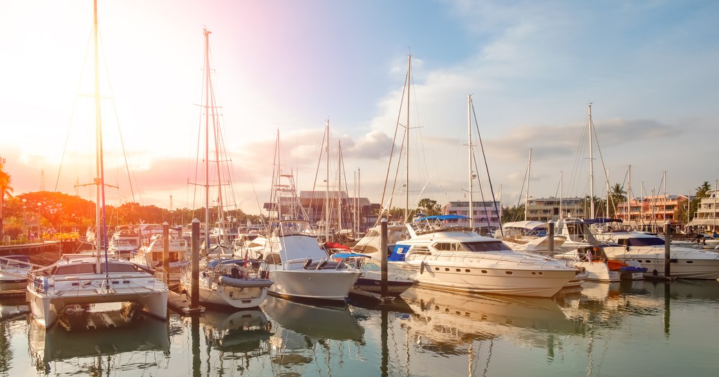 sunsets casts an orange glow over the Royal Phuket Marina in Phuket, Thailand