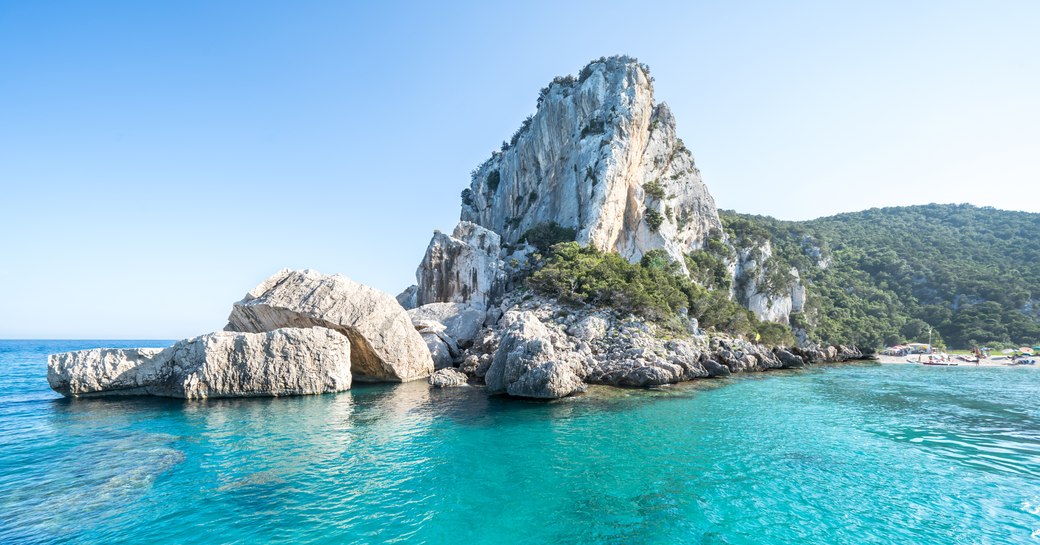 the famous beach cala luna in Sardinia where fleets of superyachts charter for a luxury holiday