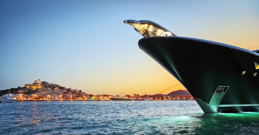 Ibezia glows in the background of Lurssen's motor yacht Phoenix 2 as she cruises the Mediterranean 