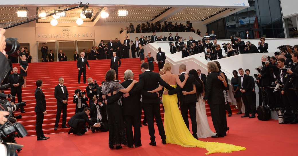 Line up of celebs facing Palais des Festivals during Cannes Film Festival photo call. Surrounded by photographers.