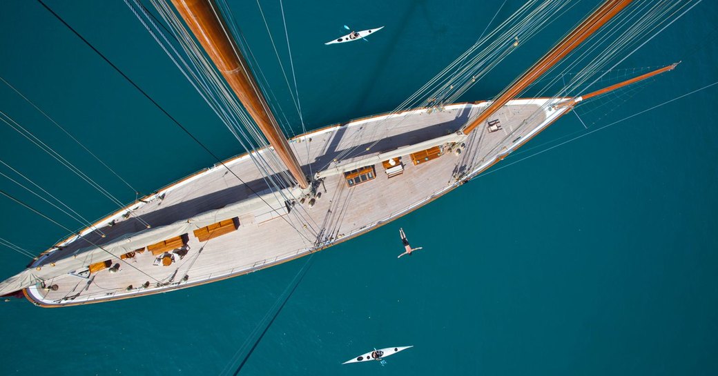 sailing yacht ELENA anchors on a Mediterranean charter as guests try out kayaks