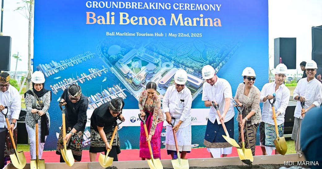 Large blue sign and people digging with spades for Bali Benoa Marina groundbreaking ceremony