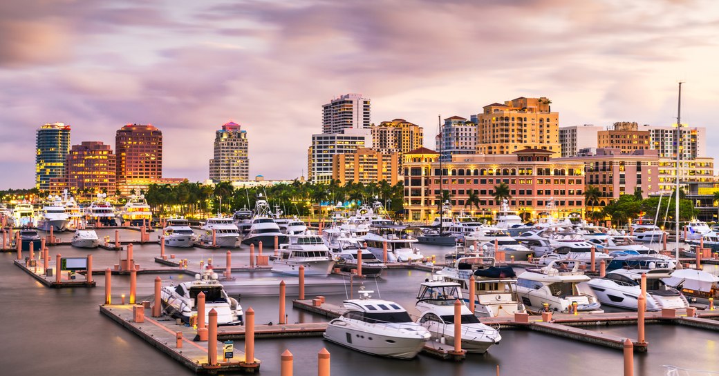 Overview of a Palm Beach marina at sunset, multiple motor yachts moored.