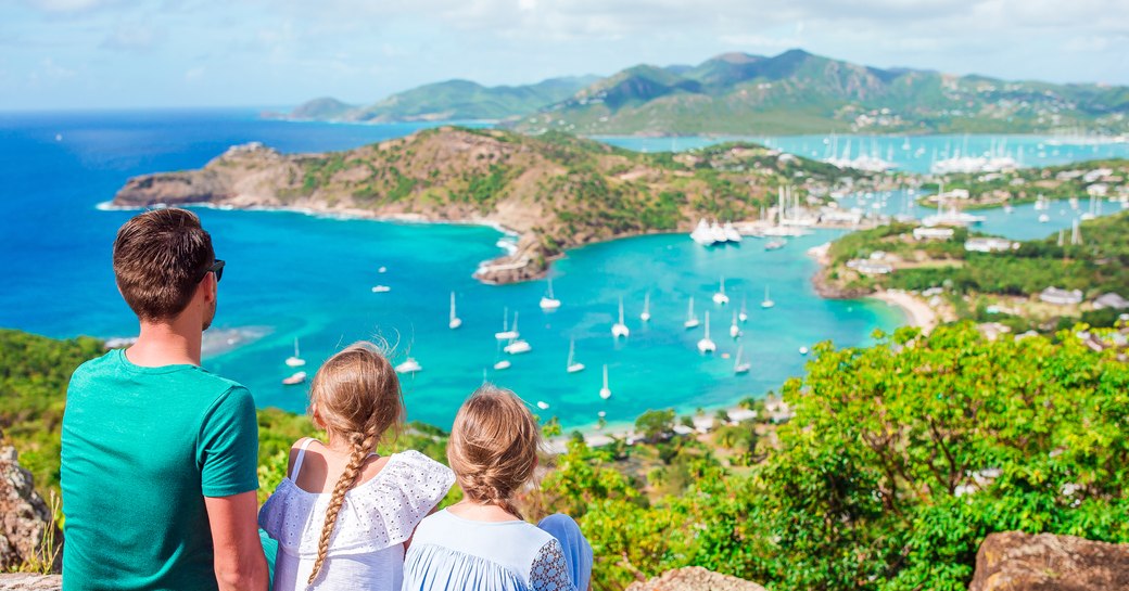 family look across Antigua's marinas from lookout point Shirley Heights