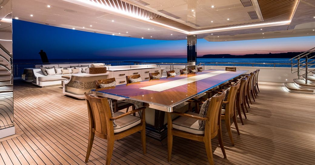 Exterior dining area with long table onboard charter yacht MAR