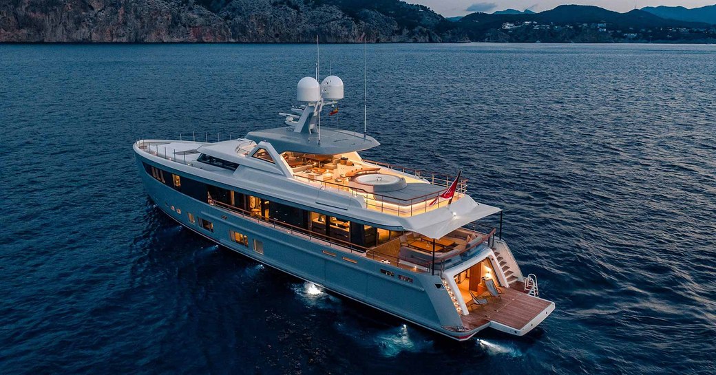 aft view of motor yacht CALYPSO as deck spaces light up for dusk