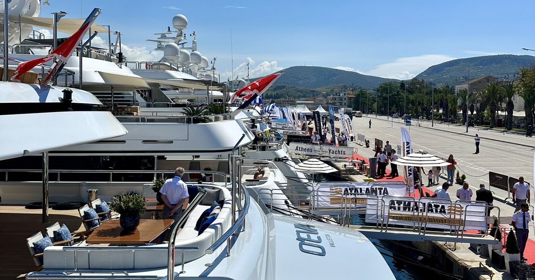 Line up of superyachts berthed at the Meditertanean Yacht Show, with visitors exploring each yacht.