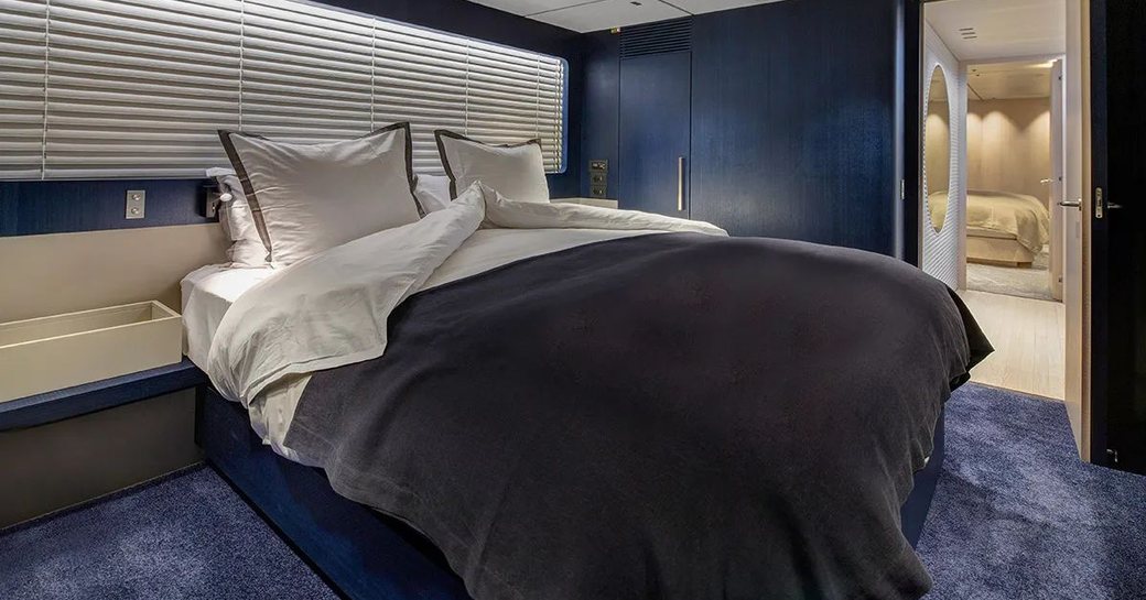 Cabin and double bed on luxury yacht ARSANA with blue walls and door open