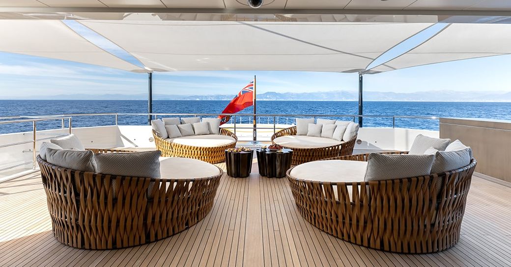 Aft deck seating area onboard charter yacht LA DATCHA, wicker seats facing each other with sweeping view of the sea