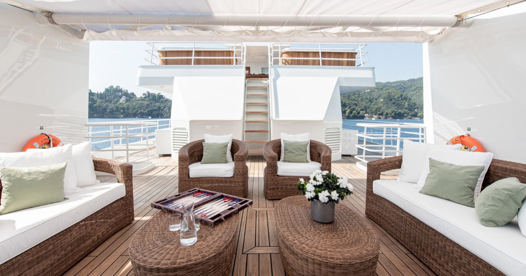 Lightly covered seating and rattan tables on superyacht Bleu De Nimes