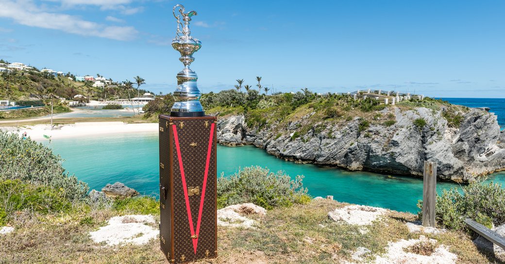 America's Cup trophy stands on Louis Vuitton suitcase in beautiful Bermudan bay