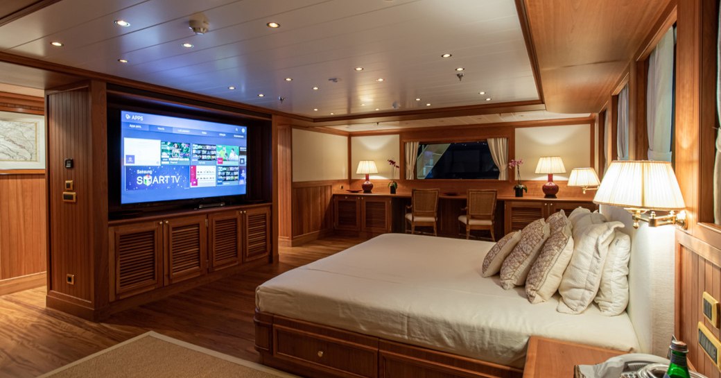 Large cabin on superyacht Bleu De Nimes with bed and large flatscreen TV on wall