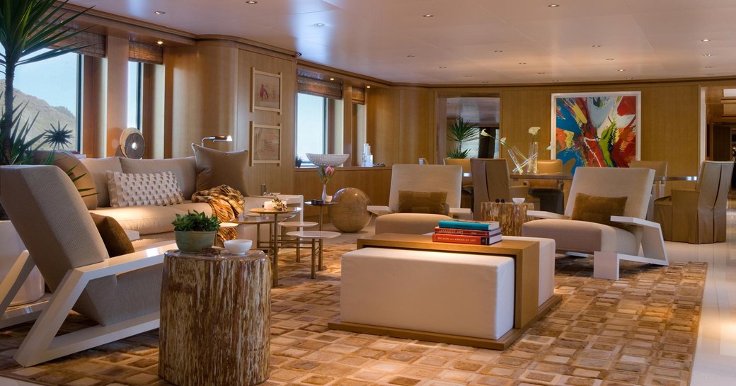 main salon with light coloured wood panels and modern furniture on board superyacht HELIOS