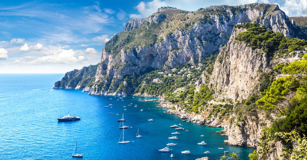Mediterranean islands with yachts in the water and rocky outcrop