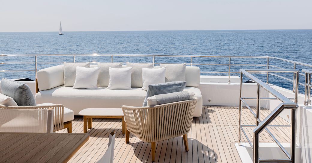 Exteriors onboard charter yacht OPTIMISM with alfresco seating area and views of the sea