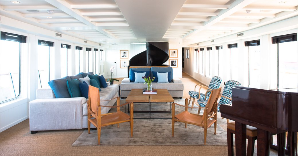 piano and seating area in the main salon of luxury yacht MENORCA