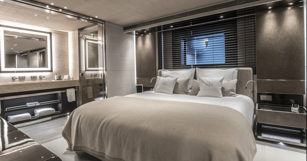 Large king size bed in cabin on superyacht SEVERIN'S with ambient lighting and mirror and vanity table to the side