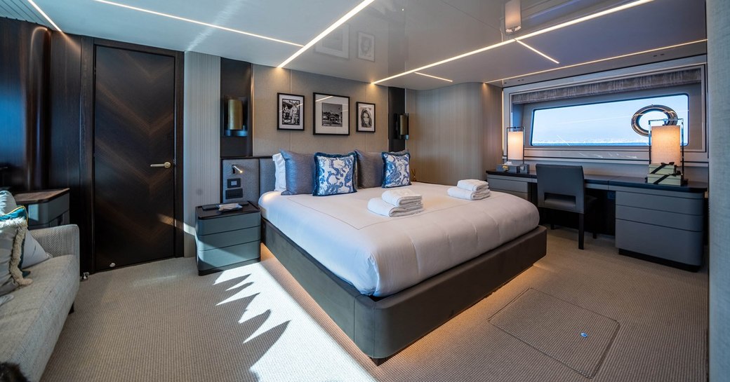 Master cabin onboard charter yacht GLASAX, central berth facing forward with wide window and bureau in the background