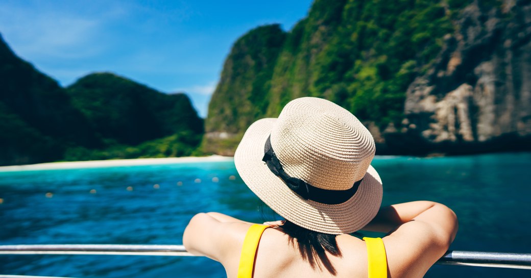 Woman on yacht looking at bay in Thailand