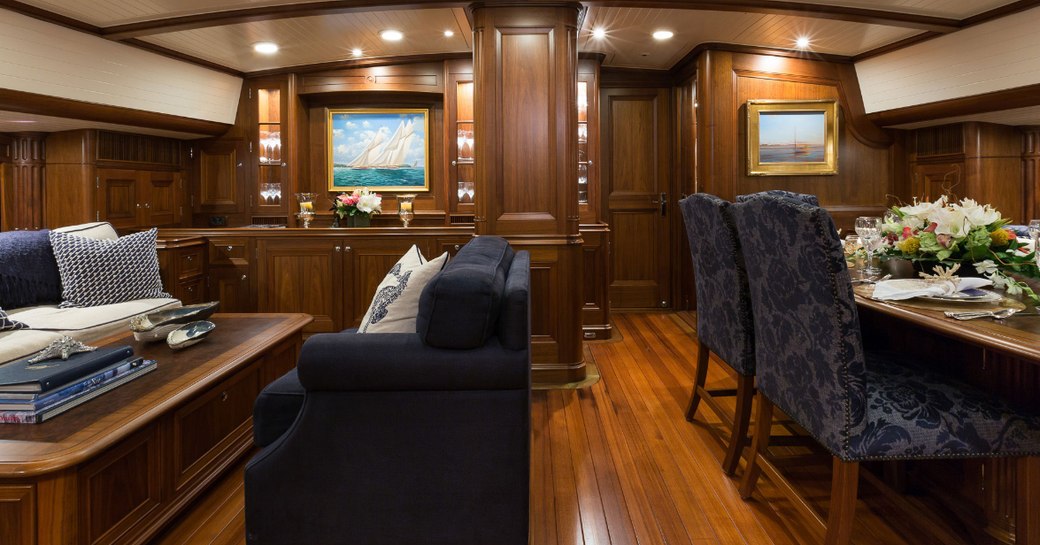 seating area and dining table in the main salon of charter yacht MARAE