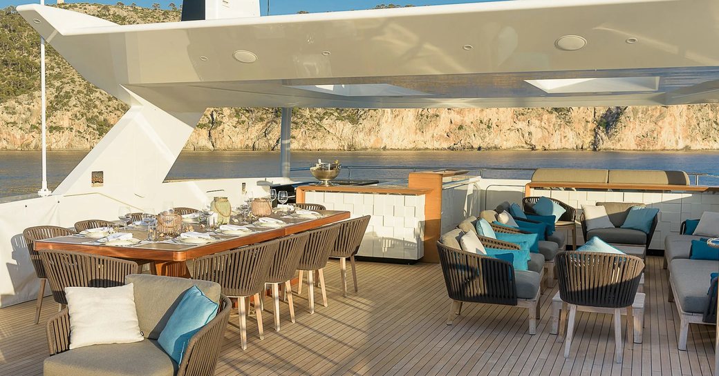 Overview of the sun deck onboard charter yacht MR T, with an alfresco dining and lounge set up