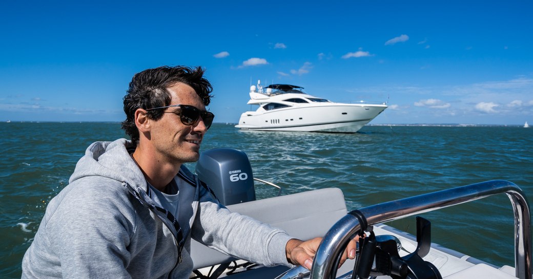 Crew driving a tender on board charter yacht CHESS