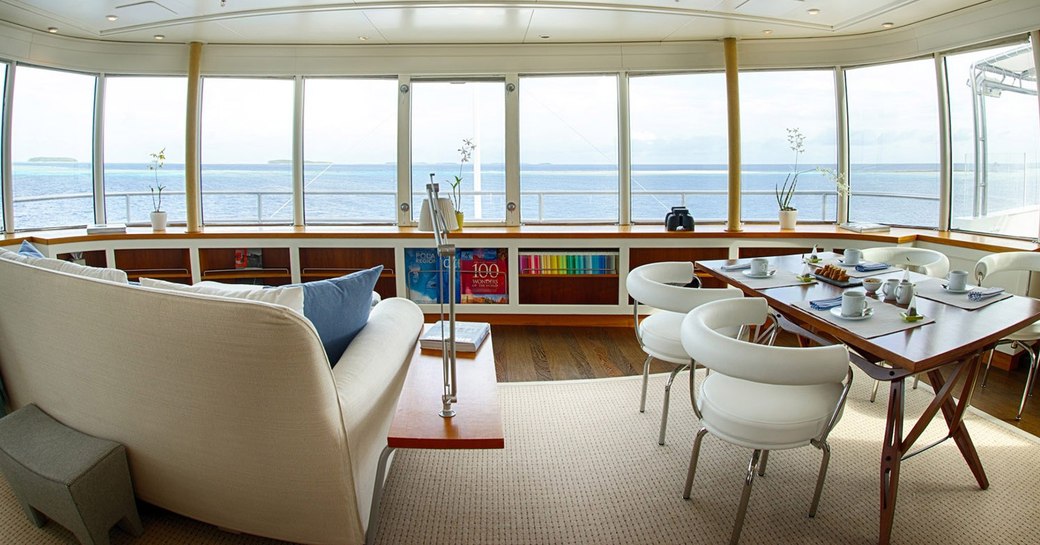 sofa and table and chairs with large windows on board superyacht SENSES 