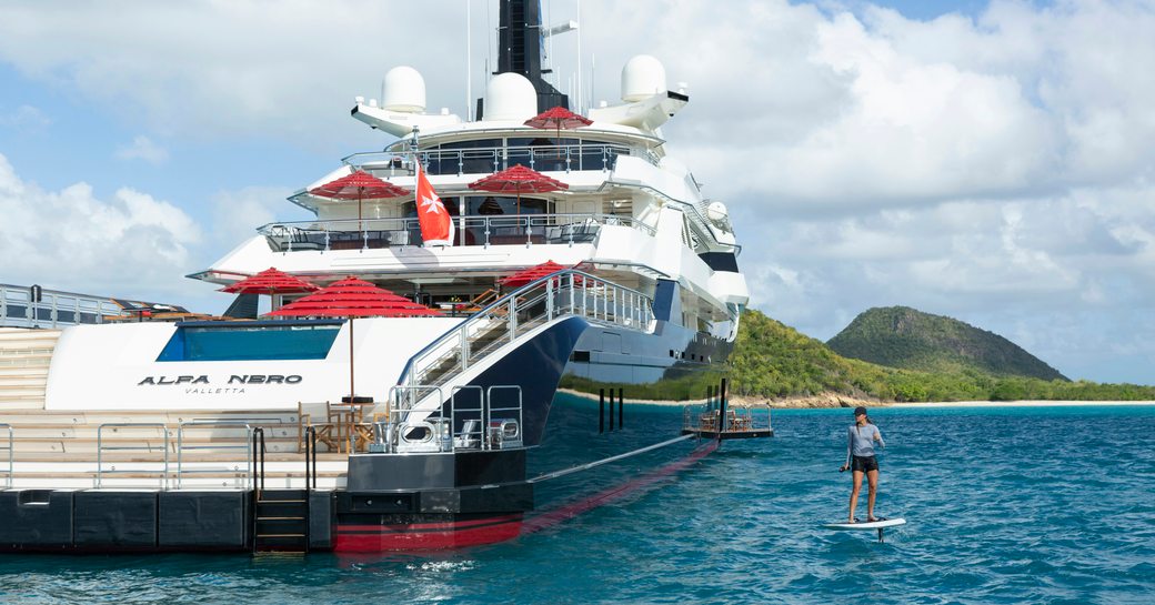 Charter yacht ALFA NERO and charter guest using water toys adjacent