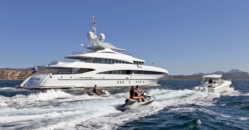 motor yacht Inception underway alongside jetskis on a Caribbean yacht charter