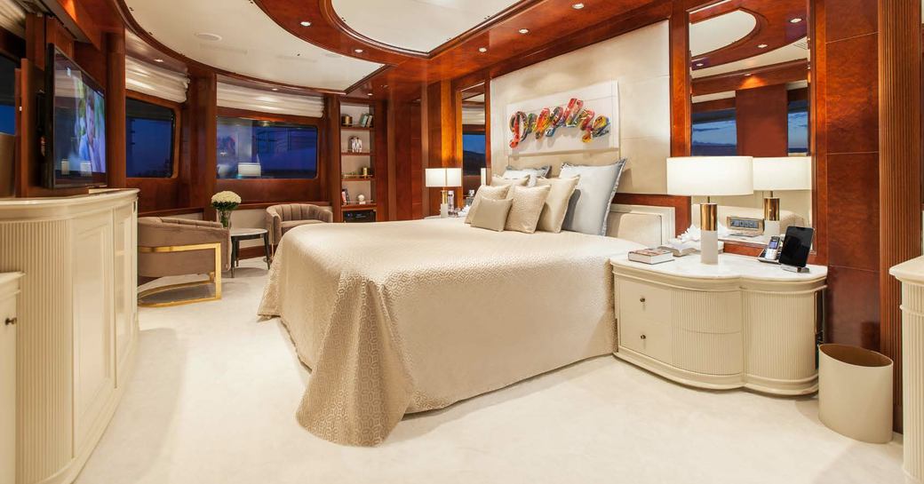 Double bed in Cabin on O'MEGA superyacht with pastel colors and wooden interior