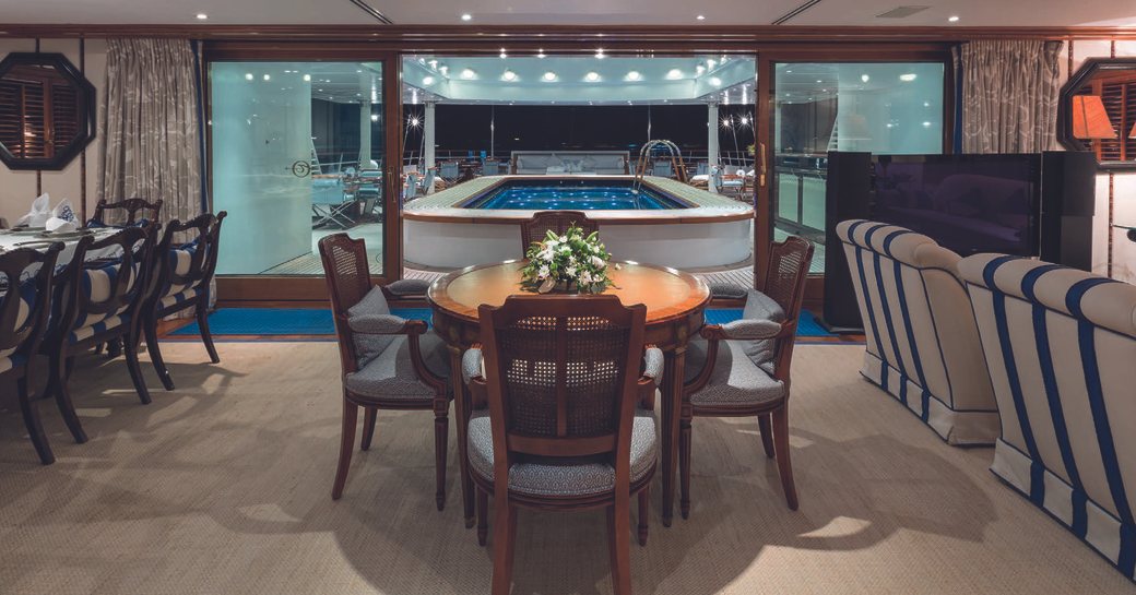 The formal dining space and swimming pool of superyacht Grand Ocean