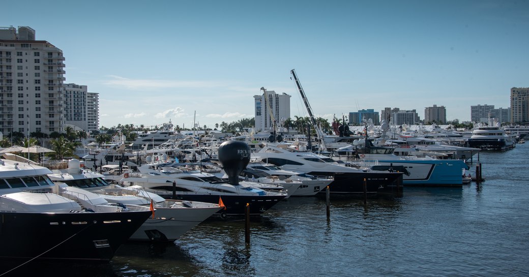 Yachts lined up at FLIBS2019 with high rise buildings in background