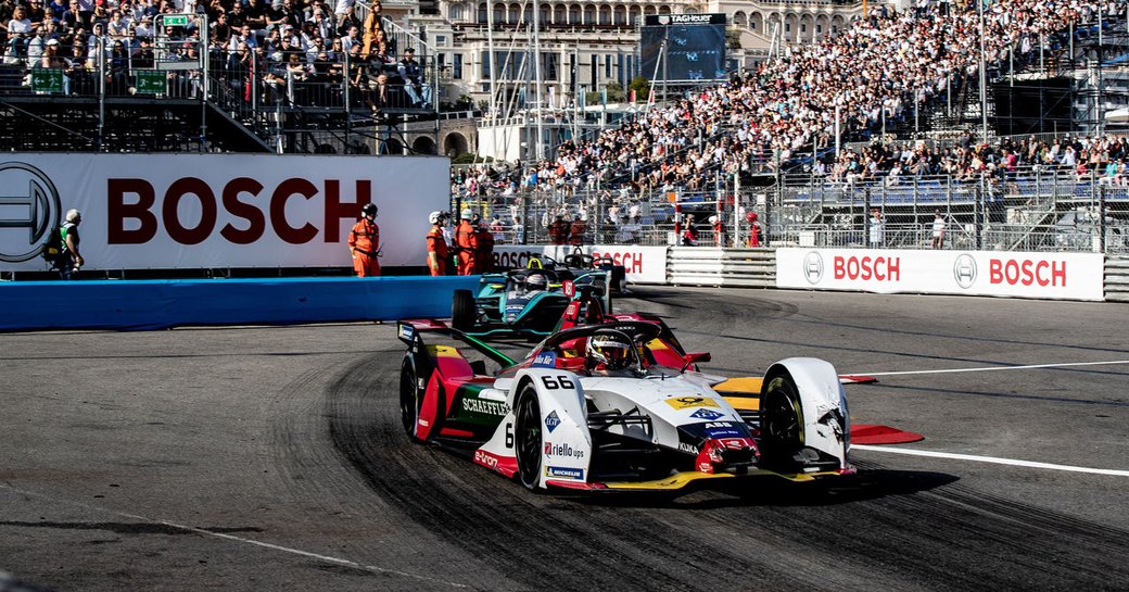 Racers taking part in Monaco E-Prix, surrounded by track and stands full of spectators.