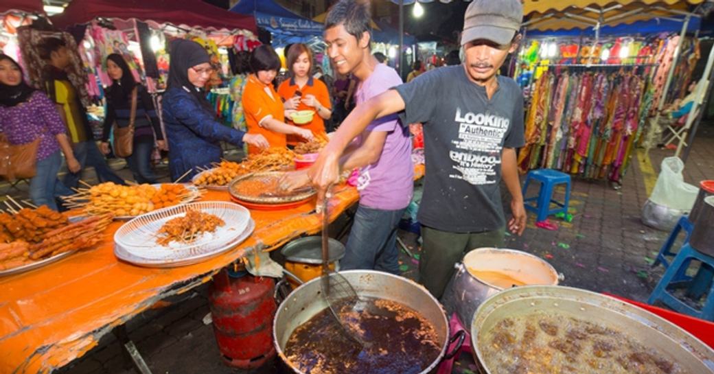A man serves up traditional food at a local macan stall in Malaysia