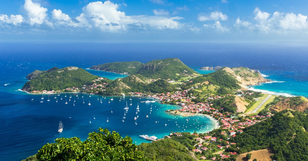 Island Town with hilly, green interior and lots of yachts on the water in Guadeloupe