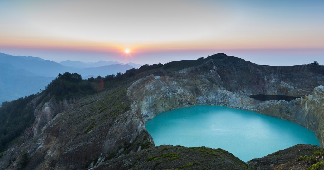 A crater lake of Mount Kelimutu as the sun sets