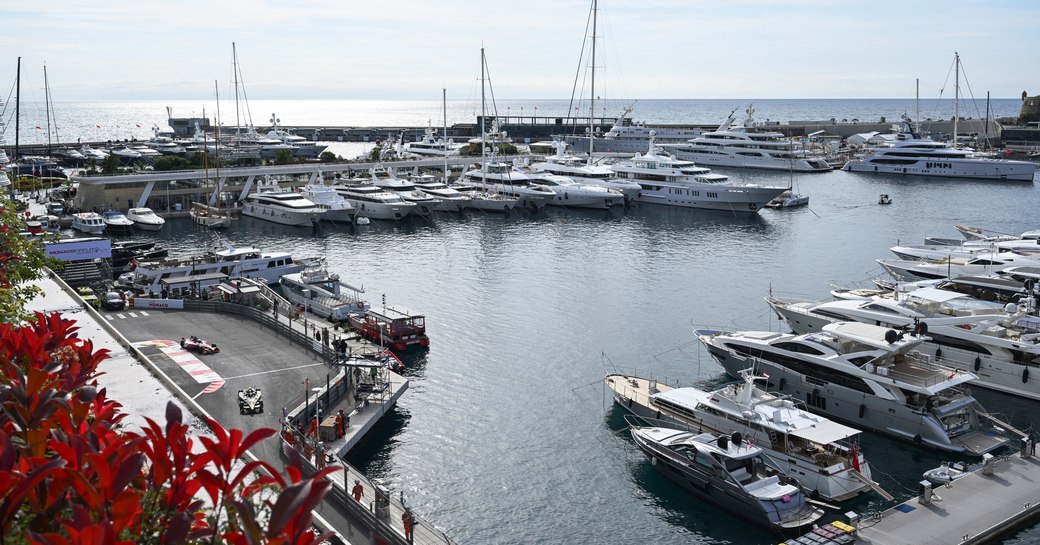 Stoffel Vandoorne, DS Penske, DS E-Tense FE23, leads Sacha Fenestraz, Nissan Formula E Team, Nissan e-4ORCE 04 by Port Hercule and berthed superyacht charters