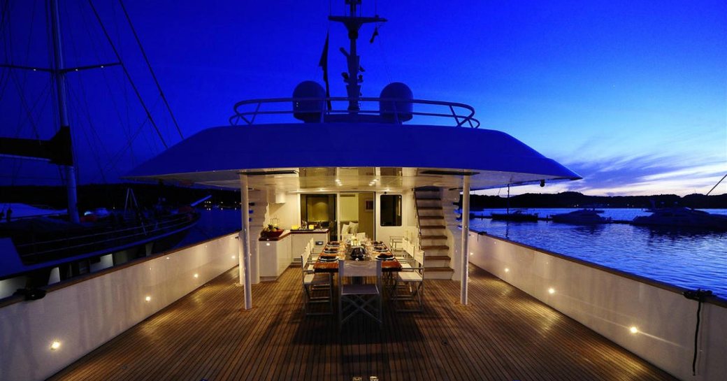 alfresco dining setup at night on the upper deck aft of luxury yacht BERZINC 