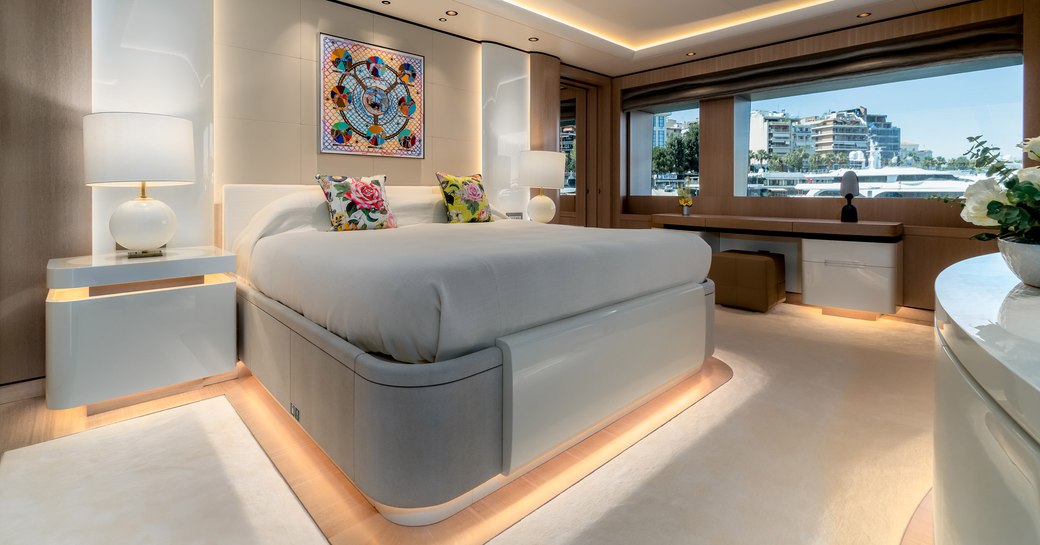 Large stateroom on superyacht O'PARI, with buildings visible through window to the right hand side