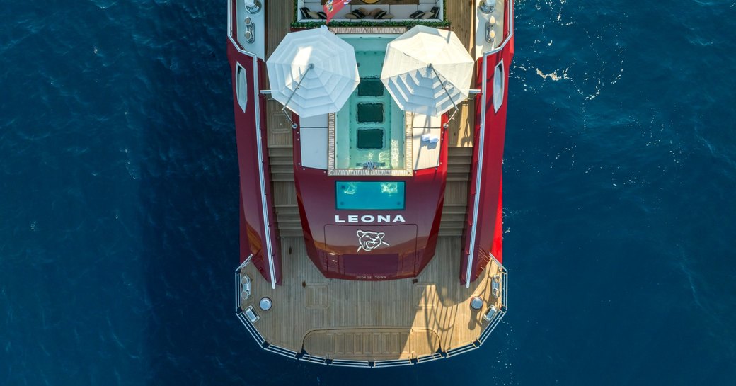 Aerial view looking down on the aft deck and swim platform of superyacht LEONA, surrounded by sea.