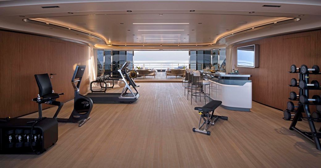 Interiors of the beach club with gym equipment onboard superyacht charter MALIA