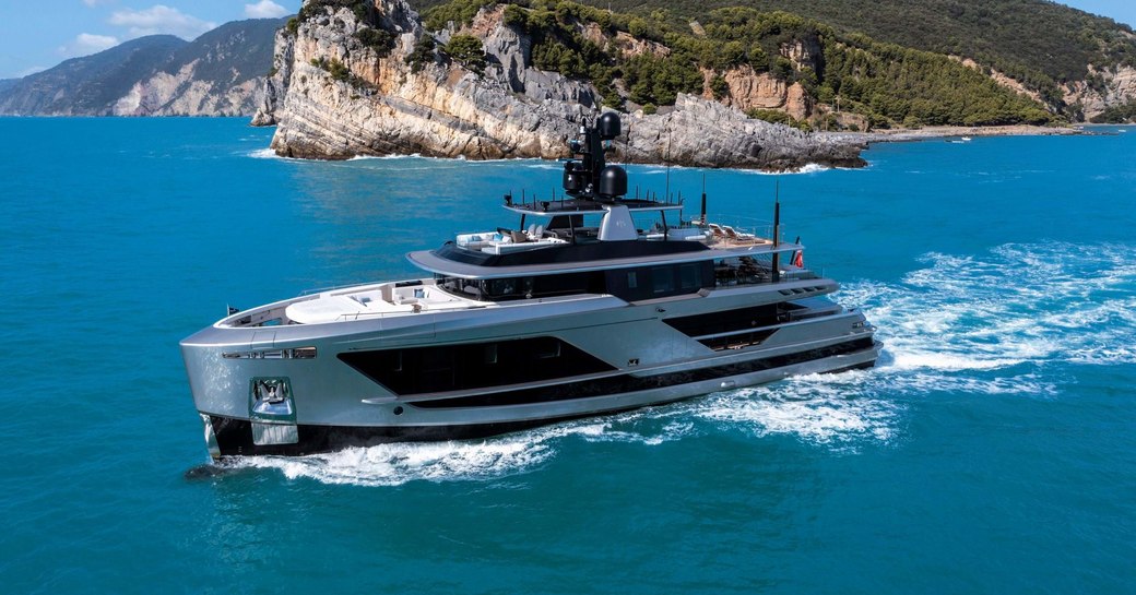 Charter yacht ENTERPRISE underway, surrounded by sea and an island in the background