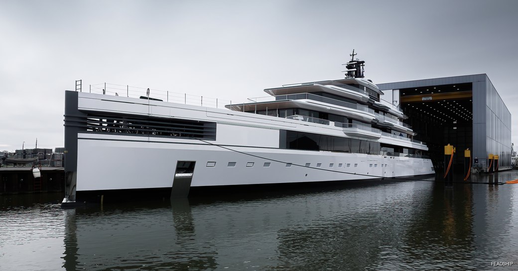 Front angle view of the bow of superyacht ULYSSES leaving a construction shed at the Feadship facility