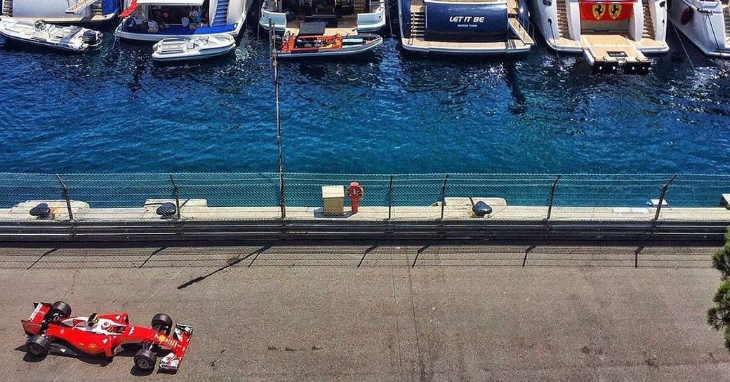 Aerial image of car on the race circuit opposite a fleet of charter yachts during the Monaco Grand Prix