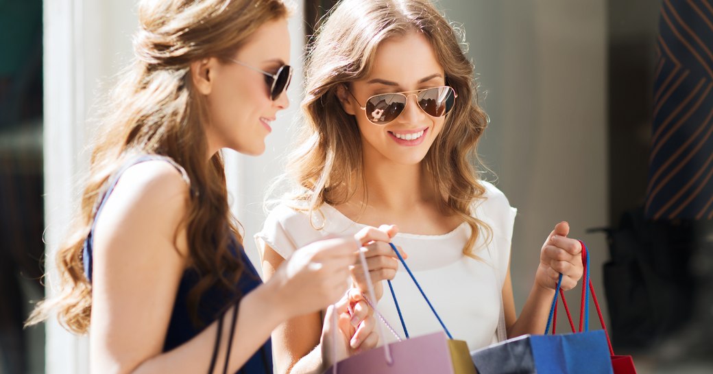 women in the sunshine carrying designer shopping bags in monaco