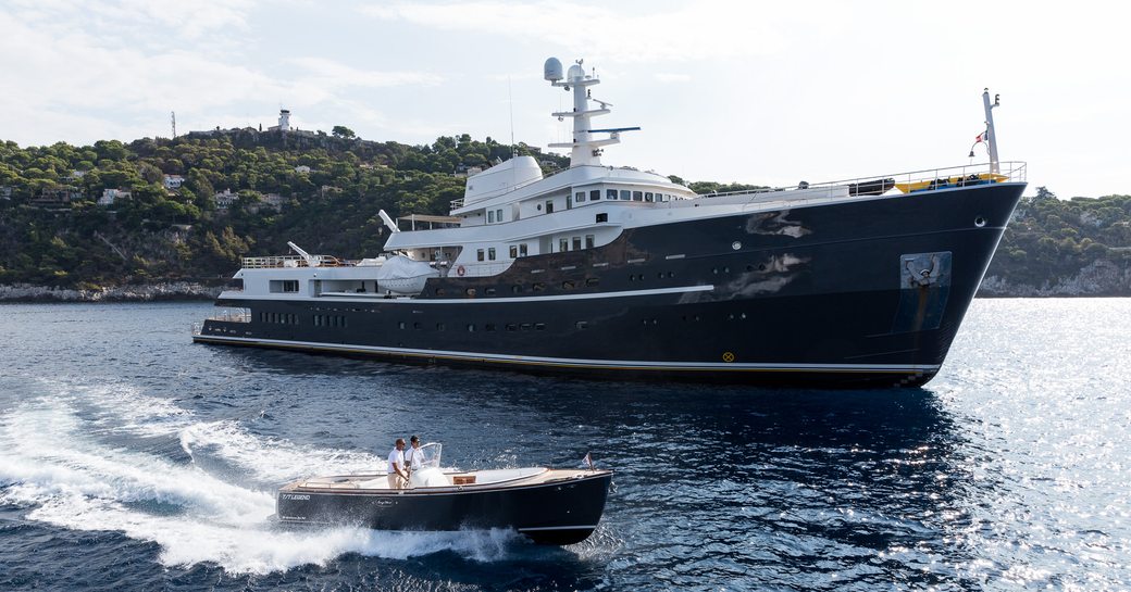 Charter yacht AQUA LARES at anchor with tender running alongside