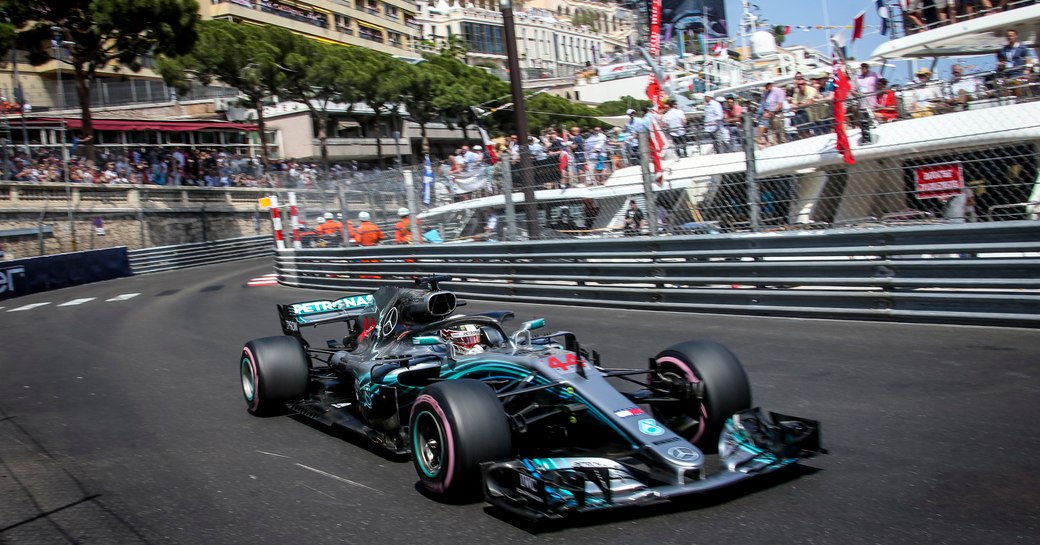 Formula one car racing at the Monaco Grand Prix racing past yachts